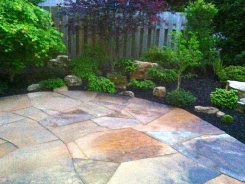 My brother Seth replaced the slate patio with quarried stone that blends with similar pavers that wend through the garden. The pavers pick up the color of the boulders we brought in.